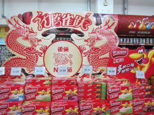 Nestlé-Produktaufsteller mit rot-goldenen Drachen. © at